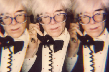 Paige Powell Andy Warhol on the telephone in his tiny office at his studio Con Edison building New York City