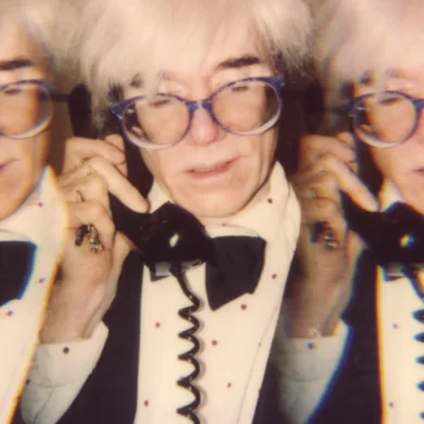 Paige Powell Andy Warhol on the telephone in his tiny office at his studio Con Edison building New York City