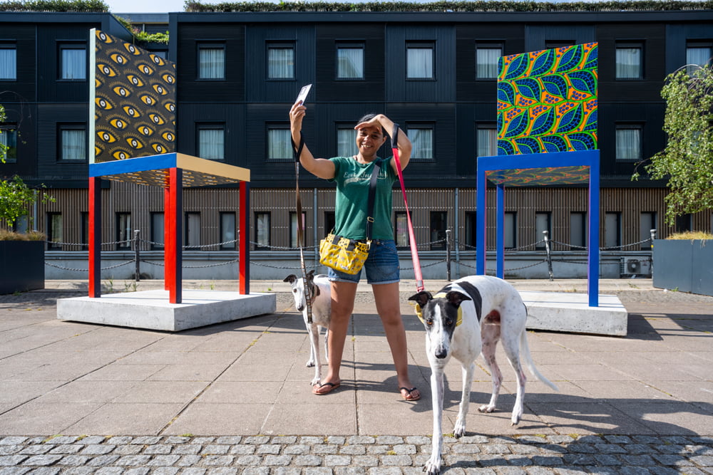A person taking a selfie with Yinka Ilori's Types of Happiness installation at the Royal Docks